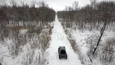 从空中观看越野车6x6，在冬天的森林里骑在白雪覆盖的道路上，后景